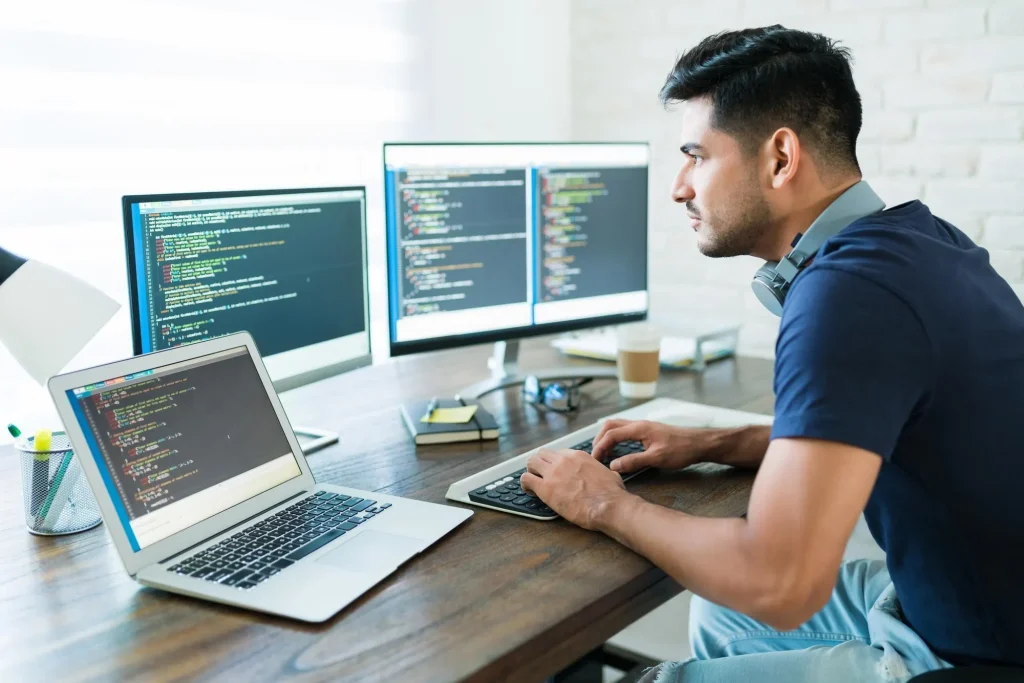 side-view-attractive-hispanic-software-developer-programming-using-computer-while-working-from-home